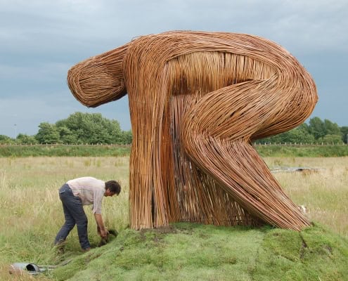Unieke houten kunstinstallatie in een open veld.